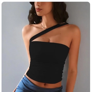 Detail of black one-shoulder yoga top with asymmetric cutout and high-stretch fabric