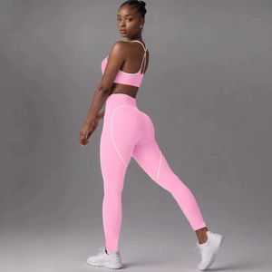 Detail view of high-waisted pink yoga set with curved white stitching on gym leggings