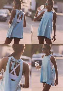 Detailed back view of light blue yoga top with open back and stylish bow tie detail