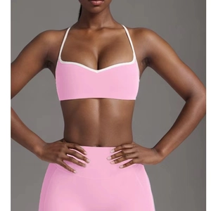 Detailed view of pink yoga set with V-neck sports bra and white contrast piping accents