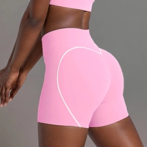 Detail view of pink high-waisted yoga shorts with heart pattern and lifting effect