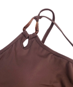 Détail du haut de yoga marron avec anneau en résine écaillée et découpe en goutte d'eau
