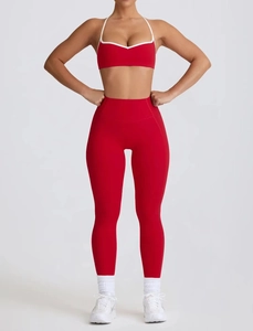 Detailed view of red yoga sports bra with white trim and high-waist seamless leggings