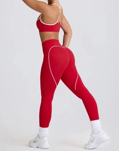 Detail of red yoga leggings showing white heart-shaped contrast stitching and push-up effect