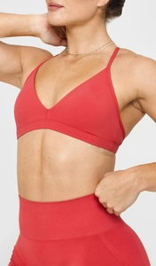 Detail eines roten Sport-BHs mit V-Ausschnitt und nahtloser High-Waist Yoga-Leggings