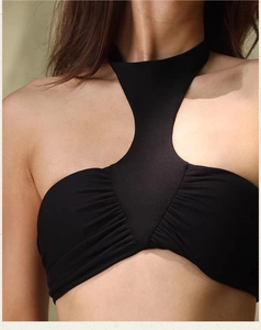Detail of black halter yoga bra featuring ruched chest design and T-shaped neckline