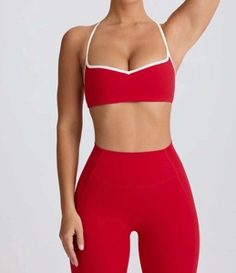 Detail of red yoga set with V-neck sports bra featuring white contrast piping and leggings