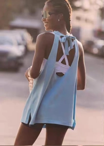 Detail of light blue yoga top featuring open back design and stylish bow-tie decoration