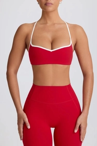 Close-up of red high-elastic sports bra with white trim and matching high-waist yoga leggings