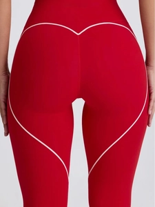 Detail view of red yoga leggings showing the heart-shaped stitching on the back hip area