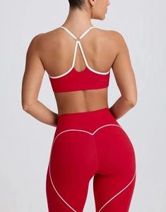 Detail of red yoga set featuring white contrast binding and heart-shaped stitching on leggings