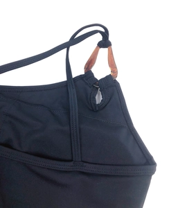 Détail d'une brassière de sport noire avec anneau élégant en écaille ambrée sur la bretelle