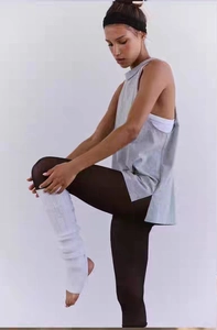 Detail of light beige ribbed stirrup leg warmers for yoga or dance training