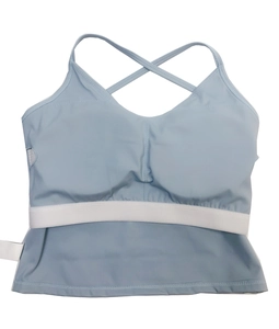 Detail van lichtblauwe yoga-sportbeha met gekruiste bandjes en een witte elastische band