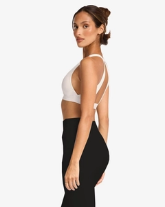 Detailed side view of white criss-cross sports bra and black high-waisted yoga shorts