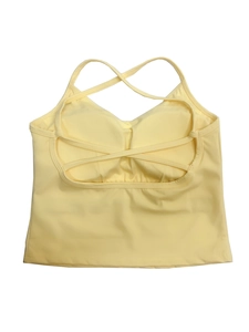 Detail van lichtgeel yogavest met gekruiste rugbandjes en ingebouwde borstkussentjes