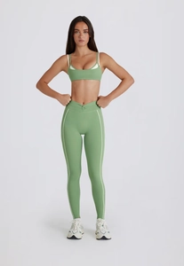 Détail de l'ensemble de yoga vert avocat avec legging à taille croisée et liserés