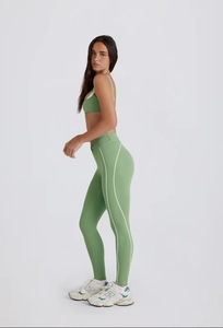 Détail de l'ensemble de yoga vert avec legging taille haute et bandes blanches latérales