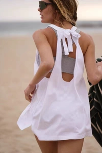 Detail view of the open back tie-up design on a loose white yoga cover-up top