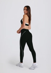 Detail of cross-back yoga bra and high-waist leggings with white piping for women