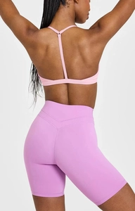 Rückansicht von rosa Sport-BH mit Y-Trägern und lila Yoga-Shorts mit hoher Taille