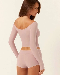 Detail of yoga set showing open shoulder long sleeve top and slim fitness shorts from back