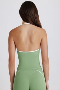 Back view of a green yoga set with halter neck design and white contrast piping detail