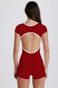 Rear view of deep red yoga bodysuit featuring a white contrast trim and large open back design