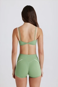 Détail du nœud croisé au dos et des coutures blanches sur cet ensemble de yoga
