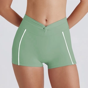 Detail of high-waist light green yoga shorts with V-shaped waistband and white stripes