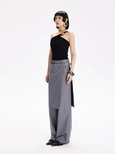 Détail du haut noir asymétrique à boucle et pantalon large à superpositions irrégulières
