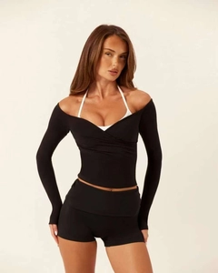 Detail view of layered yoga set with off-shoulder wrap top and athletic shorts