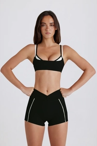Détail de l'ensemble de sport noir avec bordures blanches et short à taille en V
