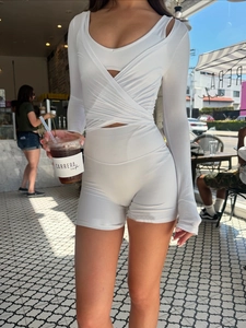 Dettaglio del cardigan da yoga bianco con design incrociato a V e pantaloncini abbinati