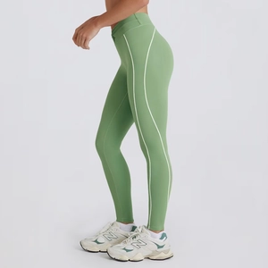 Detail view of high-waist green yoga leggings with white curved side stripe decorations