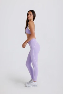 Detailed side view of lilac yoga set with white curved piping on leggings for leg shaping