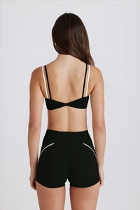 Vue arrière détaillée d'un ensemble de yoga noir avec soutien-gorge torsadé et short
