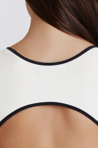 Detail of contrast color yoga bodysuit featuring open back and square neck design