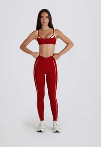 Détail de l'ensemble de yoga rouge avec liserés blancs et legging à taille en V