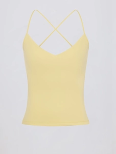 Detail van geel yogavest met lage V-hals en dunne gekruiste schouderbandjes op de rug