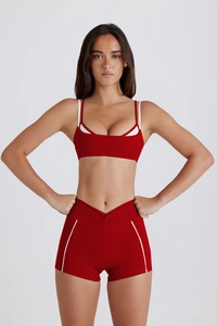Détail de l'ensemble de yoga rouge avec short croisé et brassière à doubles bretelles