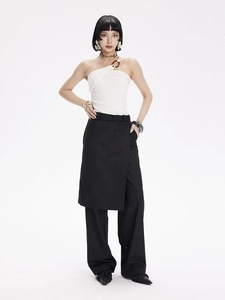 Détail du haut de yoga blanc à une épaule avec anneau en métal et pantalon large noir