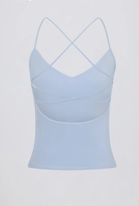 Detail van een lichtblauwe yoga sport bh met dunne gekruiste bandjes en een V-halslijn