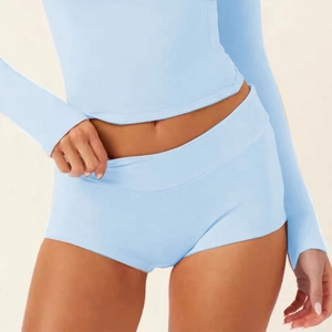 Close-up of light blue high-waisted fitness shorts and long-sleeve yoga top fabric detail