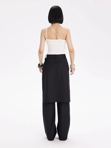 Détail du haut en maille à une épaule et du pantalon large noir multicouche de derrière