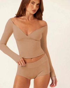 Detail of camel yoga set featuring long sleeve wrap top and matching fitted shorts