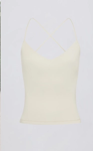 Detail van gekruiste dunne schouderbanden en V-hals op de crème yoga tanktop