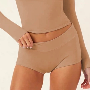 Detail of camel yoga set featuring long sleeve cropped top and high waist sports shorts