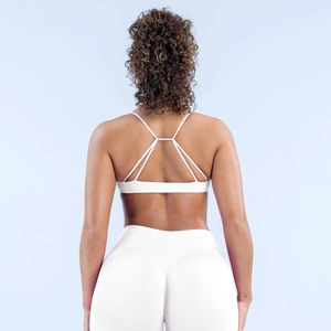 Detailansicht des weißen nahtlosen Sport-BHs mit Kreuzgurten und High-Waist-Leggings