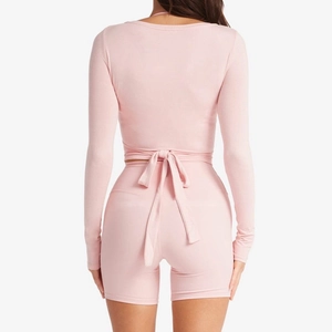 Set da yoga rosa con top a maniche lunghe allacciato dietro e pantaloncini a vita alta